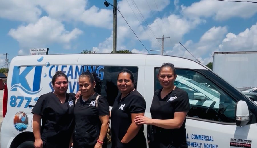 Four KI Cleaning team members in uniform in front of the branded company van